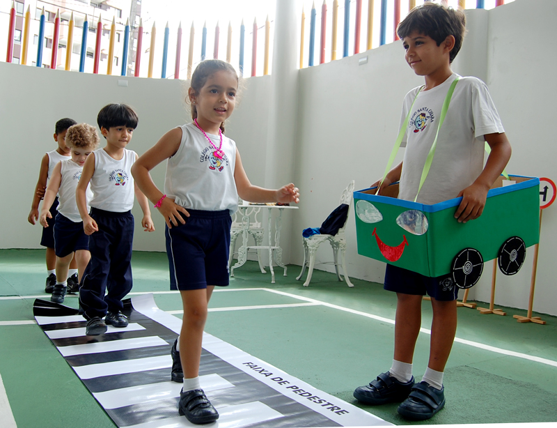 Crianças aprendem como atravessar na faixa