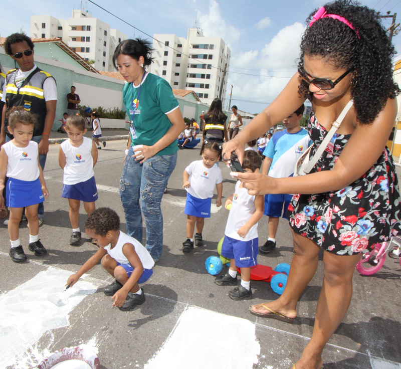 A mãe do aluno Leo Santos, a estudante Juliana Santos elogia campanha pintando a faixa