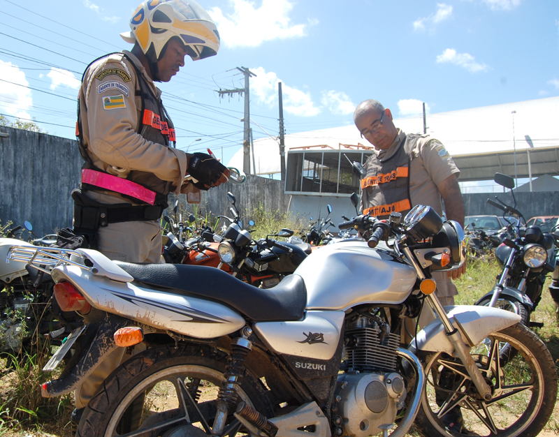 Agentes de Trânsito ao lado de motocicleta recuperada no bairro Orlando Dantas (Foto: Cleverton Ribeiro)